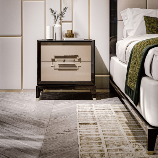 Luxury Two-Tone Lacquered Bedside Cabinet A stylish bedroom features the Luxury Two-Tone Lacquered Bedside Cabinet adorned with decorative items, including a vase with foliage and books. A bed with white linens and green accents is partially visible. The room has accent wall panels and a herringbone-pattern wooden floor with a geometric rug.