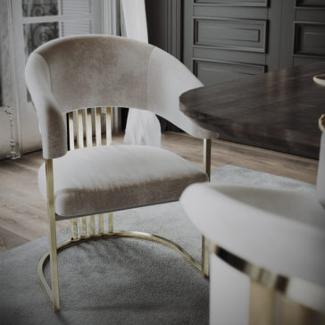 Modern Art Deco Style Curved Dining Chair The Modern Art Deco Style Curved Dining Chair, featuring plush light gray velvet upholstery and gold metallic accents, is positioned near a dark wooden table in a sophisticated, elegantly designed room with wooden flooring and decorative panels on the walls.