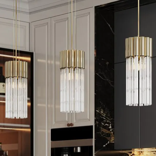 A modern kitchen interior features a pair of Contemporary Glass Tube Pendant Lights suspended from the ceiling. The backdrop showcases light-colored cabinetry and a touch of dark marble countertop, with bottles and kitchenware partially visible behind the glass-front cabinets.