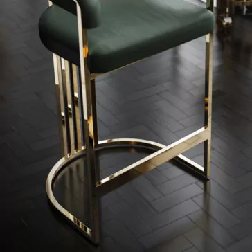 Modern Art Deco Style Curved Bar Stool A close-up of a Modern Art Deco Style Curved Bar Stool with a green cushion, featuring a sleek gold metal frame. The stool is placed on a dark, herringbone-patterned wooden floor, which adds contrast and highlights the elegant design of the bar stool.