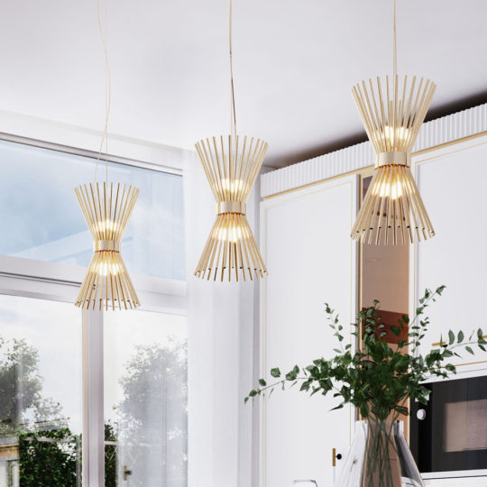 A modern kitchen features the stylish Modern Gold Plated Pendant Light with wooden slats and warm lighting, hanging from the ceiling. The background includes large windows showcasing a view of greenery, white cabinetry, and a countertop adorned with a potted plant and kitchenware.
