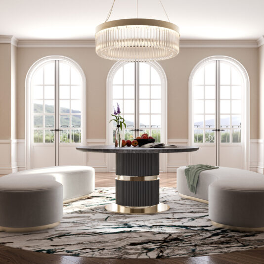 A contemporary dining room showcases the Round Modern Ribbed Veneer Dining Table adorned with a centerpiece, encircled by circular white ottomans on a patterned rug. Expansive arched windows provide abundant natural light, and an elegant chandelier hangs above the table. The space is decorated in neutral tones.