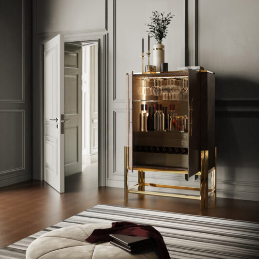 A stylish modern room features the Veneer Drinks Cabinet With Feather Handle, a sleek piece stocked with bottles and glasses. This cabinet, adorned with gold feather handles, stands on a wooden floor next to an open door that reveals another elegantly decorated room. In the foreground, there is a round striped rug and a cushioned ottoman.