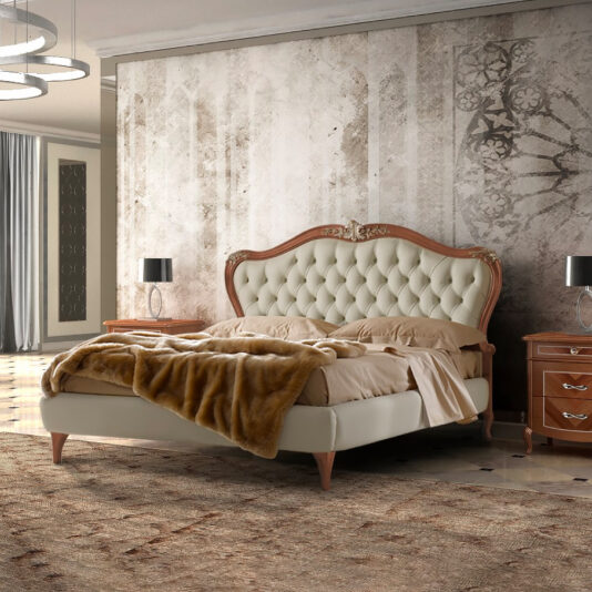 A luxurious bedroom features an Ornate Walnut Veneer Button Upholstered Bed adorned with beige bedding and a brown fur throw. The bed is flanked by wooden nightstands, each accompanied by a black lamp. The walls showcase a vintage patterned design, complementing the room's elegant furnishings and decor.