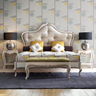 Classic Style Ornate Button Upholstered Bed A stylish bedroom showcases the Classic Style Ornate Button Upholstered Bed with its elegant beige headboard. The bed is decorated with pillows and bedding in geometric patterns, featuring hues of yellow, white, and gray. Flanking the bed are two exquisite bedside tables, each topped with a metallic lamp. A bench at the foot of the bed enhances the timeless ambiance. All set against a backdrop of modern geometric wallpaper, this bedroom epitomizes classic sophistication.
