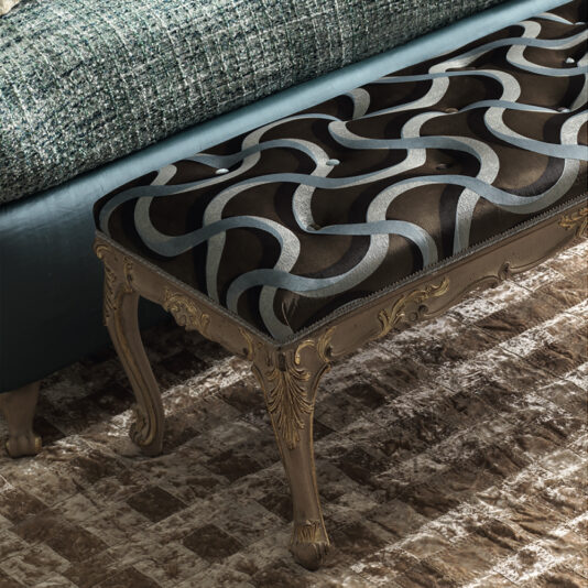 Ornate Rococo Style Bench An Ornate Rococo Style Bench with intricate carvings on its wooden legs is placed on a textured rug. The bench features a cushioned seat with an interlocking pattern made of silver and black curved lines, alongside a tufted fabric backrest.
