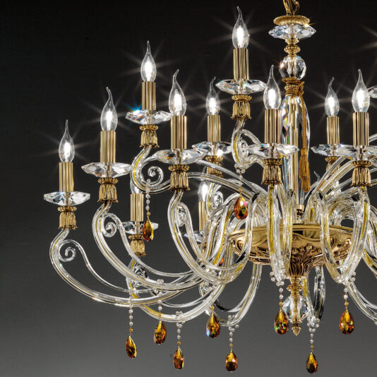 Candelabra Style Chandelier With Swarovski Crystals Presenting the Candelabra Style Chandelier With Swarovski Crystals: an ornate, gold-colored chandelier adorned with multiple candle-like lights and intricate details. This stunning piece features clear Swarovski crystals hanging from its branches, reflecting light to create a mesmerizing sparkling effect. Set against a dark background, the chandelier's elegance is beautifully highlighted.