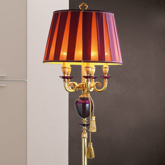 The Classic Candelabra Style Speckled Glass Floor Lamp boasts a vintage charm with its red and gold striped shade, ornate gold details, and four candle-like light fixtures reminiscent of a timeless candelabra. Its base is elegantly adorned with decorative elements and tassels, making it a perfect fit for any two-tone walled setting.