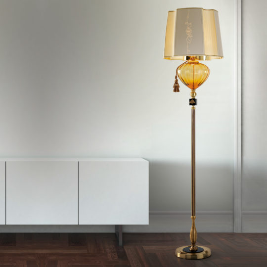 A modern living room with a sleek white cabinet and the Classic Style Amber Glass Floor Lamp, which features a decorative shade and a tassel. The room showcases a minimalist design with wooden flooring and a light gray wall in the background, blending contemporary aesthetics with classic style.