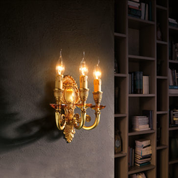 A **Triple Candle Style Wall Light**, featuring three lit candle-shaped bulbs, is mounted on a dark gray wall. To the right, there's a floor-to-ceiling bookshelf filled with various books and small decorative items. The scene exudes a warm, cozy ambiance.