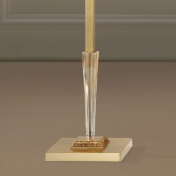 A close-up image of the lower part of the Luxury Classical Floor Lamp. The stylish, modern lamp features a square, gold-colored base with a central vertical rod extending upwards. The rod has a clear, faceted section adding an element of elegance and sophistication to the overall design.