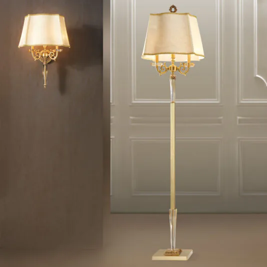 High End Classic Wall Light An elegant floor lamp paired with the High End Classic Wall Light, featuring brass and crystal details along with beige fabric shades. The floor lamp stands on a square base to the right, while the High End Classic Wall Light is mounted on the left against a beige background. Both emit a warm light.