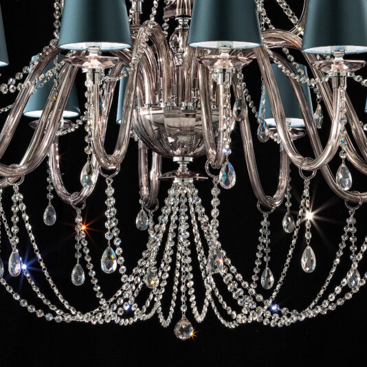 A close-up shot of the Large Modern Smoked Glass Chandelier With Shades, showcasing its intricate metalwork and adorned with multiple crystal droplets. The cascading crystals reflect light brilliantly, while the metallic-finished lampshades enhance its luxurious appearance.