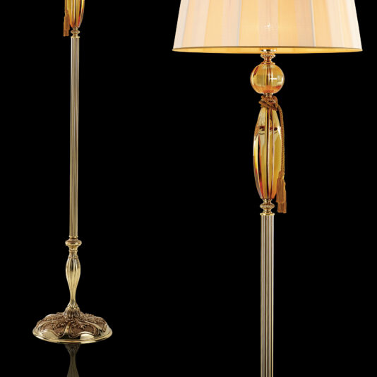 Luxury Amber Glass Floor Lamp The Luxury Amber Glass Floor Lamp is an elegant pair of gold floor lamps featuring ornate bases, slender stems, and a decorative amber glass element near the top. Each lamp boasts a cream-colored, pleated lampshade adorned with gold tassels, exuding luxury against the black background.