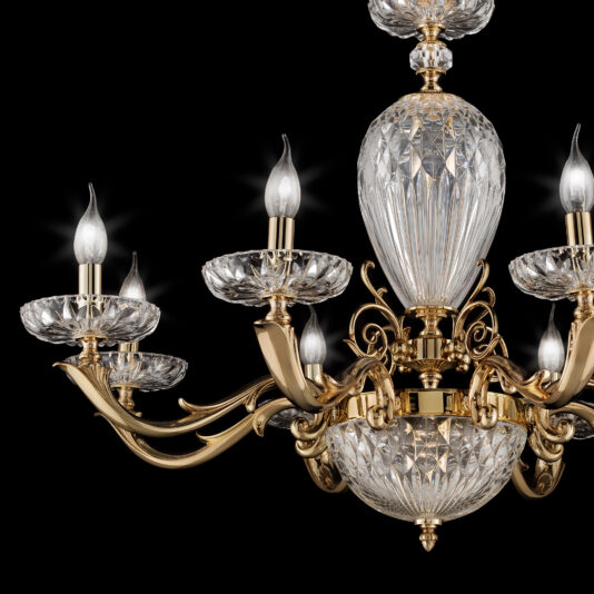 The Luxury Faceted Blown Glass Chandelier is beautifully displayed against a black background, showcasing its ornate gold detailing. Six elegant, faceted crystal arms extend outward, each topped with a candle-like light bulb. This exquisite lighting fixture exudes sophistication and style.