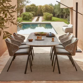 poolscape luxury garden dining table and chairs overlooking swimming pool.