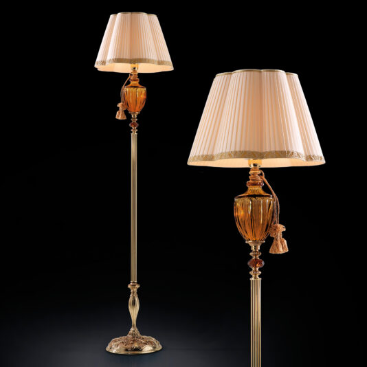 Introducing the Classic Amber Glass Floor Lamp: a set of luxurious lamps featuring timeless dimpled amber glass centers and intricate bases adorned with ornate detailing. Each lamp is topped with a beige pleated lampshade trimmed in gold. The elegant design is highlighted against a black background, showcasing their sophisticated aesthetic.