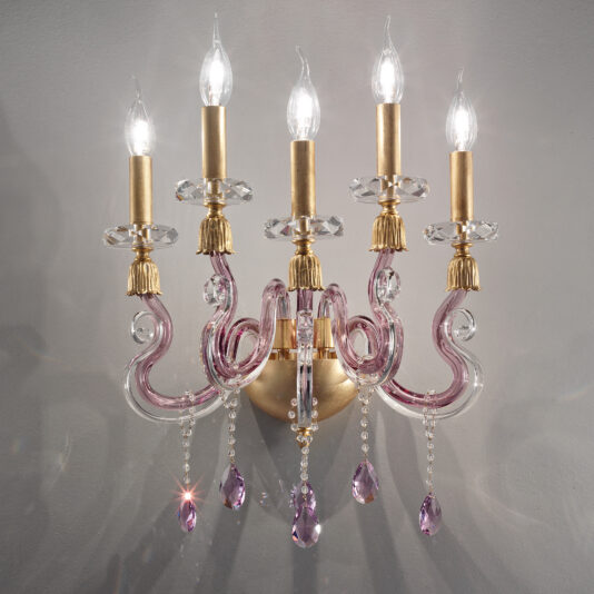 The Contemporary 5 Arm Candle Style Glass Wall Light showcases five candle-shaped bulbs and graceful, curved arms in a stunning combination of clear and light purple glass. Gold accents enhance its charm, while dangling purple crystal pendants add a touch of luxury against the grey backdrop.