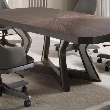 Luxury Veneered Boardroom Table A close-up of the Luxury Veneered Boardroom Table, showcasing its unique geometric wooden pattern, is surrounded by sleek, gray office chairs on wheels. The room is decorated in neutral tones and features carpeted flooring.