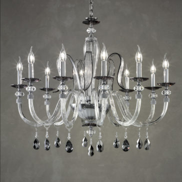The Modern Chandelier With Swarovski® Crystals features multiple candle-shaped lights, gracefully curved glass arms, and ornate hanging Swarovski® crystals. Set against a gray background, this elegant chandelier emits a warm and inviting glow, enhancing any space with a touch of sophistication and luxury.