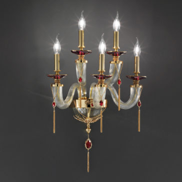 The Swarovski® Crystal Candle Style Wall Light is a luxurious wall-mounted fixture featuring five arms, each adorned with a lit candle-shaped bulb. This chandelier combines gold metal accents and red decorative elements, exuding elegance and opulence against a dark background.