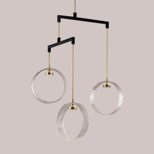 Contemporary Glass Ring Chandelier The Contemporary Glass Ring Chandelier showcases three circular textured rings hanging from a black frame by golden rods. Each ring varies in size and is suspended at different heights, resulting in an elegant and modern design set against a beige background.
