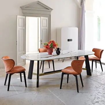 Contemporary Oval Quartz Dining Set A modern dining room with a Contemporary Oval Quartz Dining Set featuring a marble-top table and four orange chairs with black legs. The table has a centerpiece with vibrant flowers. The room showcases tall white double doors, a minimalist white fridge, and a tall arch window with a curtain.