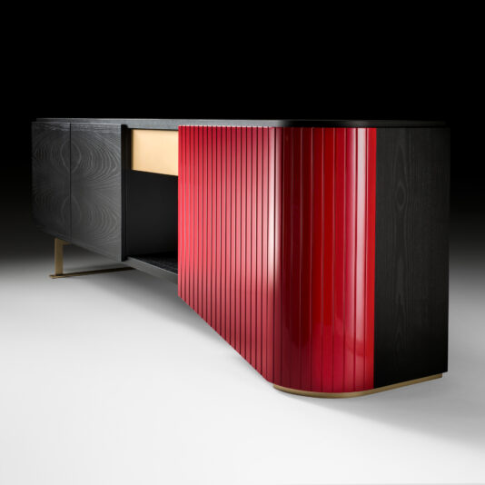 The Large Contemporary Sideboard showcases a sleek design with dark wood on the left side and glossy red vertical slats on the right. This stylish piece features a combination of open and closed storage spaces, all supported by minimalist legs against a black backdrop.