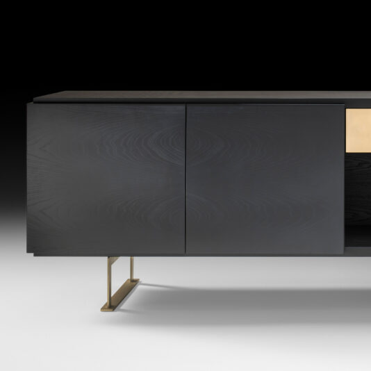 The Large Contemporary Sideboard boasts a modern dark wood finish and a sleek, minimalist design. This piece features two spacious doors on the left, while the right section showcases a contrasting light wood panel. It stands on slim, metallic legs with a gold finish, blending both style and functionality seamlessly.
