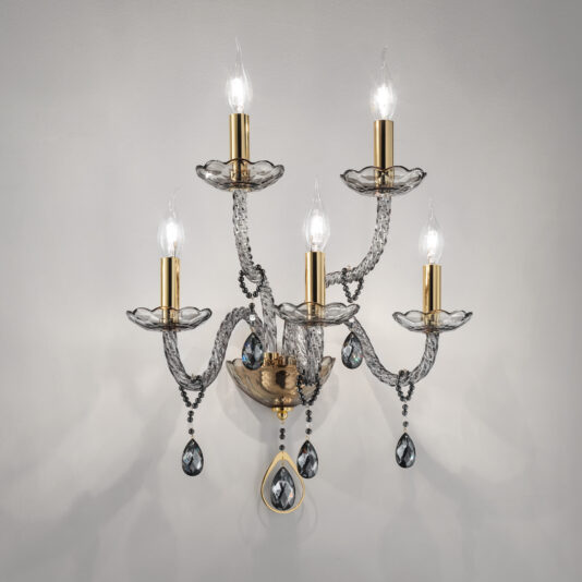 The Smoked Glass 5 Arm Wall Light showcases five candle-style bulbs, each complemented by a transparent, curved glass plate and adorned with hanging crystal pendants. The gold-toned fixtures add a sophisticated ambiance when placed against a neutral wall.