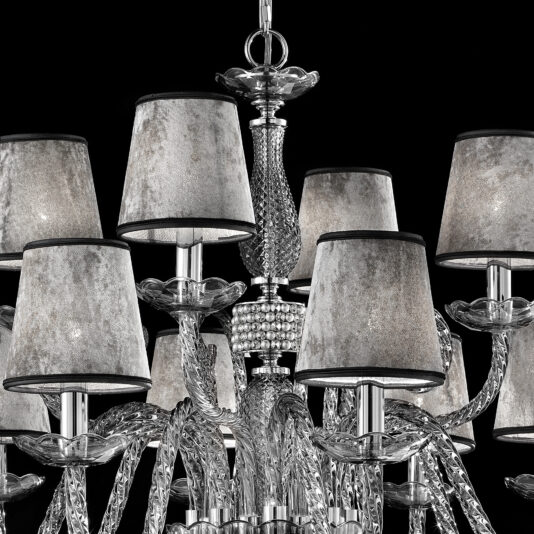 A detailed close-up of the elegant Smoked Glass Chandelier With Shades, showcasing multiple ornate light fixtures. Each fixture boasts a tarnished silver lampshade adorned with intricate glass designs and reflective metallic elements, all set against a striking black background.