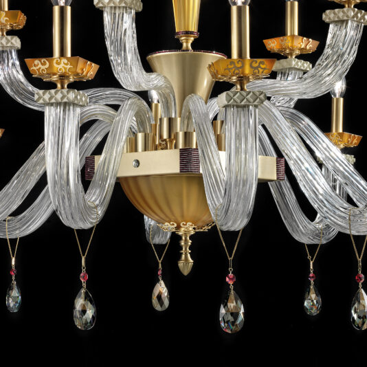 Introducing the Elegant Amber Glass Chandelier: a luxurious lighting fixture crafted from amber glass and featuring a stunning gold and brass centerpiece. Adorned with gracefully curved glass arms, this chandelier boasts candle-like light fixtures and is beautifully accented with hanging crystal pendants, each highlighted by a subtle red hue, set against an exquisite black backdrop.