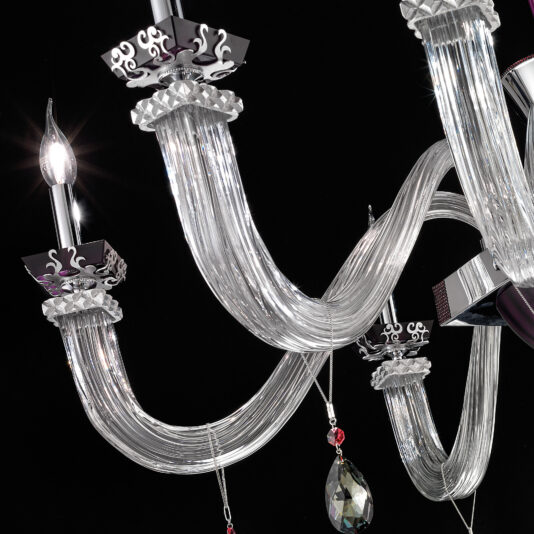 A close-up view of the Elegant Large Amethyst Glass Chandelier against a black background. This ornate fixture boasts twisted, clear glass arms with intricate silver detailing. Two candle-like lights extend from the glass arms, adorned with decorative hanging crystals and touches of amethyst glass.