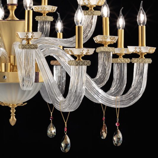 The Large Elegant Chandelier With Pendant Drops showcases numerous intricate glass arms, adorned with gold accents and candle-like light bulbs. Elegant pendant drops hang as decorative crystal ornaments from the glass arms, beautifully reflecting the light. The black background accentuates the elegance and detail of this luxurious chandelier.