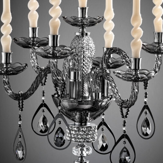 Smoked Glass Candelabra Style Candlestick A close-up view of the **Smoked Glass Candelabra Style Candlestick** showcasing twisted candle-shaped bulbs, ornate smoked glass holders, and hanging teardrop-shaped crystals. The intricate design and reflective surfaces of this candelabra-style fixture create a luxurious and sophisticated ambiance.