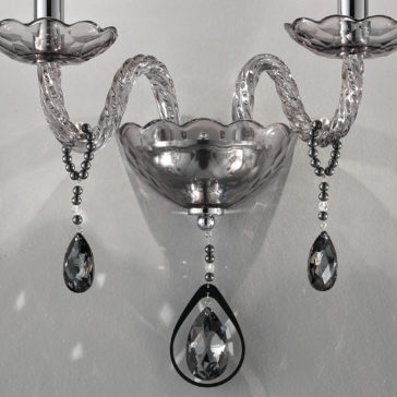 Smoked Glass Double Wall Light A close-up of the Smoked Glass Double Wall Light showcases intricate clear and smoked glass detailing. The twisted arms lead to candle-like lights, and several crystal teardrops are suspended, adding a sophisticated touch to the fixture.