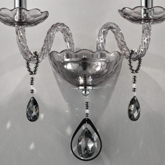 Smoked Glass Double Wall Light A close-up of the Smoked Glass Double Wall Light showcases intricate clear and smoked glass detailing. The twisted arms lead to candle-like lights, and several crystal teardrops are suspended, adding a sophisticated touch to the fixture.