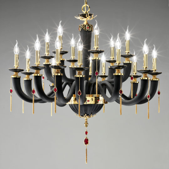 The Classic Black Chandelier With Swarovski® Crystals features 24 candle-shaped lights, curving arms, gold accents, intricate detailing, and red gemstone decorations for an elegant and opulent appearance.