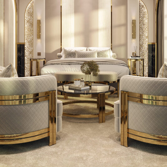 Contemporary Round Smoked Glass Coffee Table A luxurious bedroom features a plush bed with white linens and multiple pillows. Two elegant armchairs with gold accents face a **Contemporary Round Smoked Glass Coffee Table** adorned with a vase of flowers. The room is decorated in neutral tones with warm lighting and intricate wall designs.