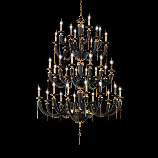Against a black background hangs the Large Classic Black Chandelier With Swarovski® Crystals, an ornate, multi-tiered masterpiece. This sumptuous fixture boasts numerous candle-like lights arranged in circular patterns and is adorned with gleaming Swarovski® crystals and golden accents, exuding a luxurious and classical aesthetic.