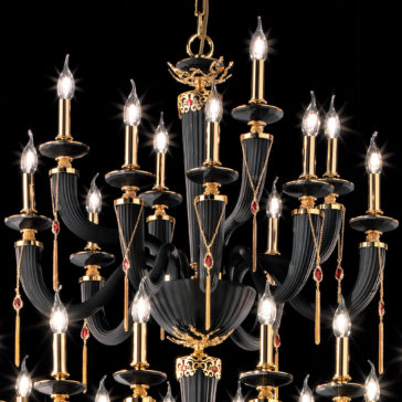 Large Classic Black Chandelier With Swarovski® Crystals The Large Classic Black Chandelier With Swarovski® Crystals features an elegant design adorned with multiple candle-style light bulbs, gold accents, and red gemstone details, creating a sophisticated and opulent ambiance.