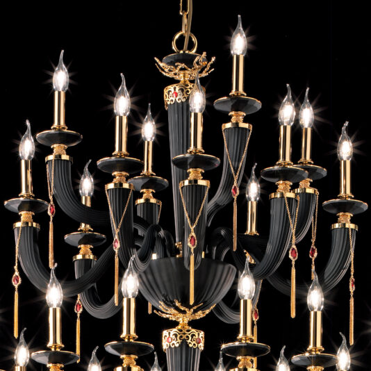 The Large Classic Black Chandelier With Swarovski® Crystals features an elegant design adorned with multiple candle-style light bulbs, gold accents, and red gemstone details, creating a sophisticated and opulent ambiance.