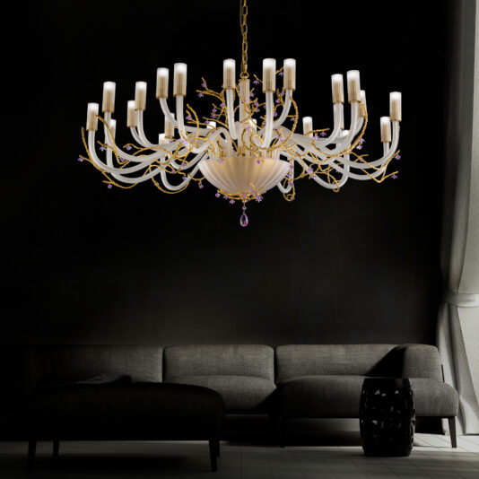 A large modern chandelier with Swarovski crystal flowers, featuring elegant gold accents and multiple candle-shaped light bulbs, hangs from the ceiling. Below the chandelier is a modern gray sectional sofa in a dark, minimally decorated room with a large window covered by sheer curtains.