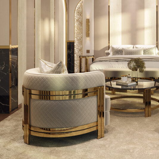 Modern Curved Armchair With Brass Frame Luxurious bedroom with elegant decor featuring the Modern Curved Armchair with Brass Frame, a glass-top coffee table with gold trim, and a modern bed adorned with pillows. Soft lighting enhances the warm, sophisticated ambiance.