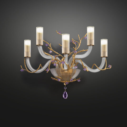 The Modern Wall Light With Swarovski Crystal Flowers features an ornate, wall-mounted chandelier with five candle-like lights. Gold-colored branches adorned with small violet crystals and an elegant violet crystal pendant hanging at the bottom complete its luxurious design. The fixture is beautifully highlighted against a dark background.