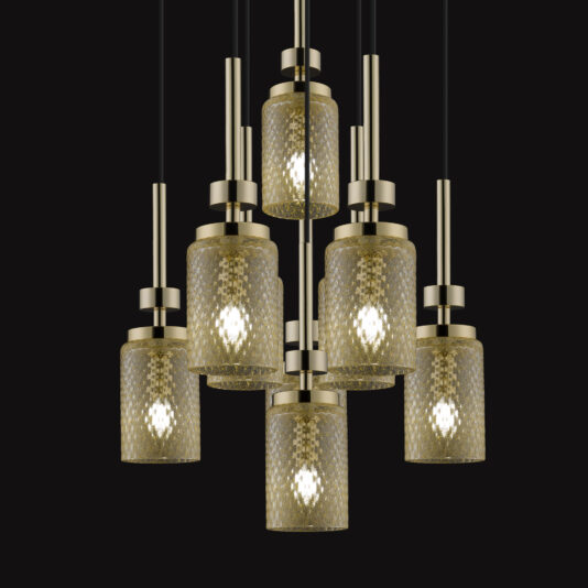 The Pendant Light Cluster With Balloton Effect Glass Shades features a modern design with seven cylindrical, gold-toned glass lampshades. Each shade has a textured Balloton effect surface that emits a bright light, complemented by sleek vertical metal supports set against a black background.