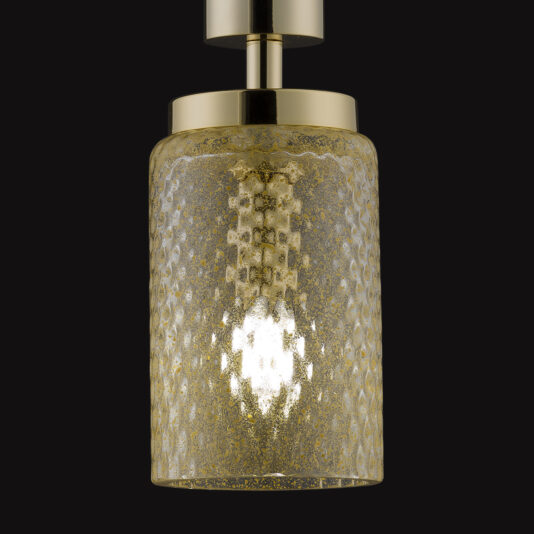 The Pendant Light With Balloton Effect Glass Shade, featuring a gold-colored cylindrical glass shade with a honeycomb pattern, hangs from a metallic fixture, casting a warm glow. The elegant design is highlighted against the black background.