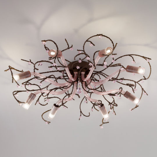 A decorative ceiling light fixture with an intricate, floral-inspired design features twisting branches capped with small pink glass flowers and Swarovski crystal accents that extend outward, holding cylindrical light bulbs that cast a soft, ambient light. The Pink Glass Branch Ceiling Light With Swarovski Crystal Flowers is mounted on a white ceiling.
