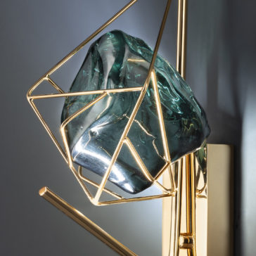 Viridian Green Crystal Rock Wall Light The Viridian Green Crystal Rock Wall Light boasts a contemporary and artistic design, featuring a large, irregularly shaped viridian green crystal rock encased in a geometric gold metal frame. This stunning piece blends natural and industrial elements seamlessly.