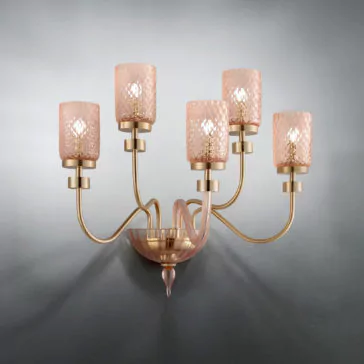 The Wall Light With Balloton Effect Glass Shades is a brass five-arm wall sconce adorned with pink Balloton effect glass shades. This elegant fixture showcases curved arms and textured lampshades, each housing a bulb, creating a sophisticated and vintage-inspired lighting piece against a plain grey background.